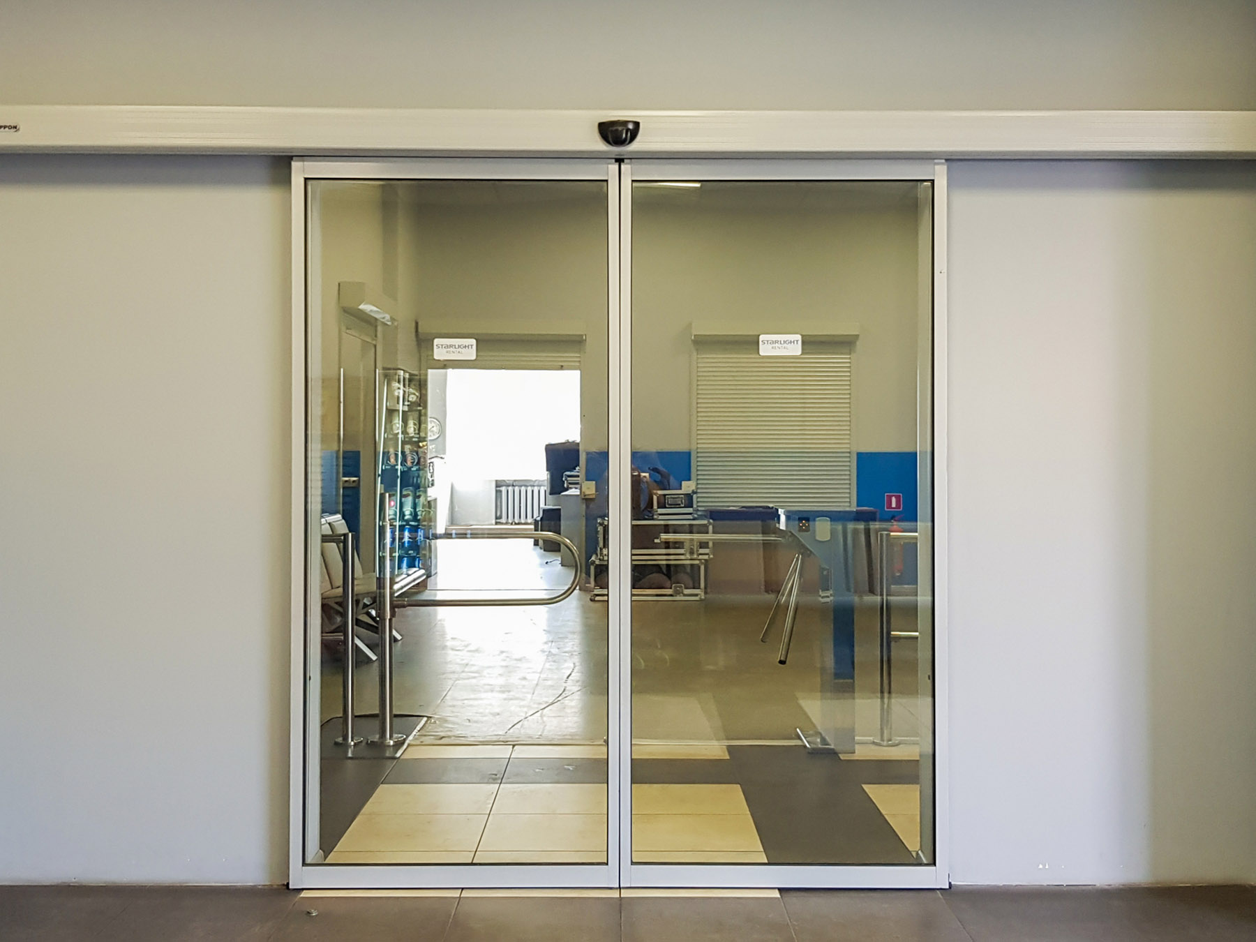 Empty sliding glass front door at the airport. Glass doors in the office. Glass entrance. Entrance to administration building equipped with automatic door